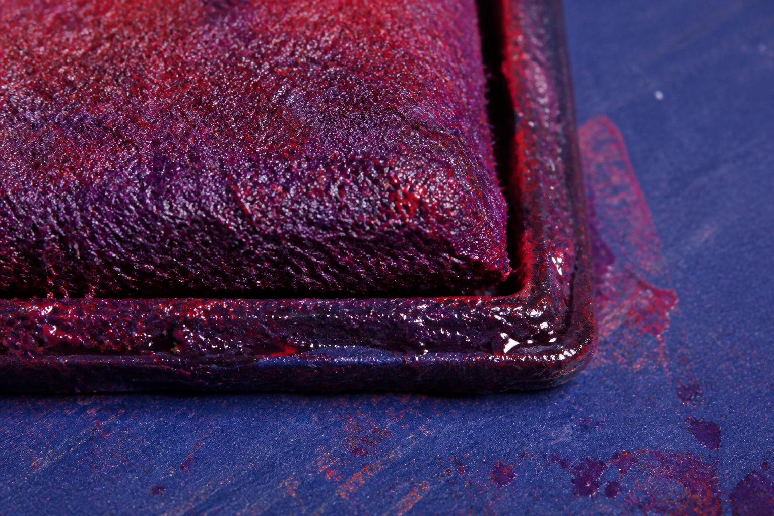 Macro of a wet red and purple rubber stamp pad