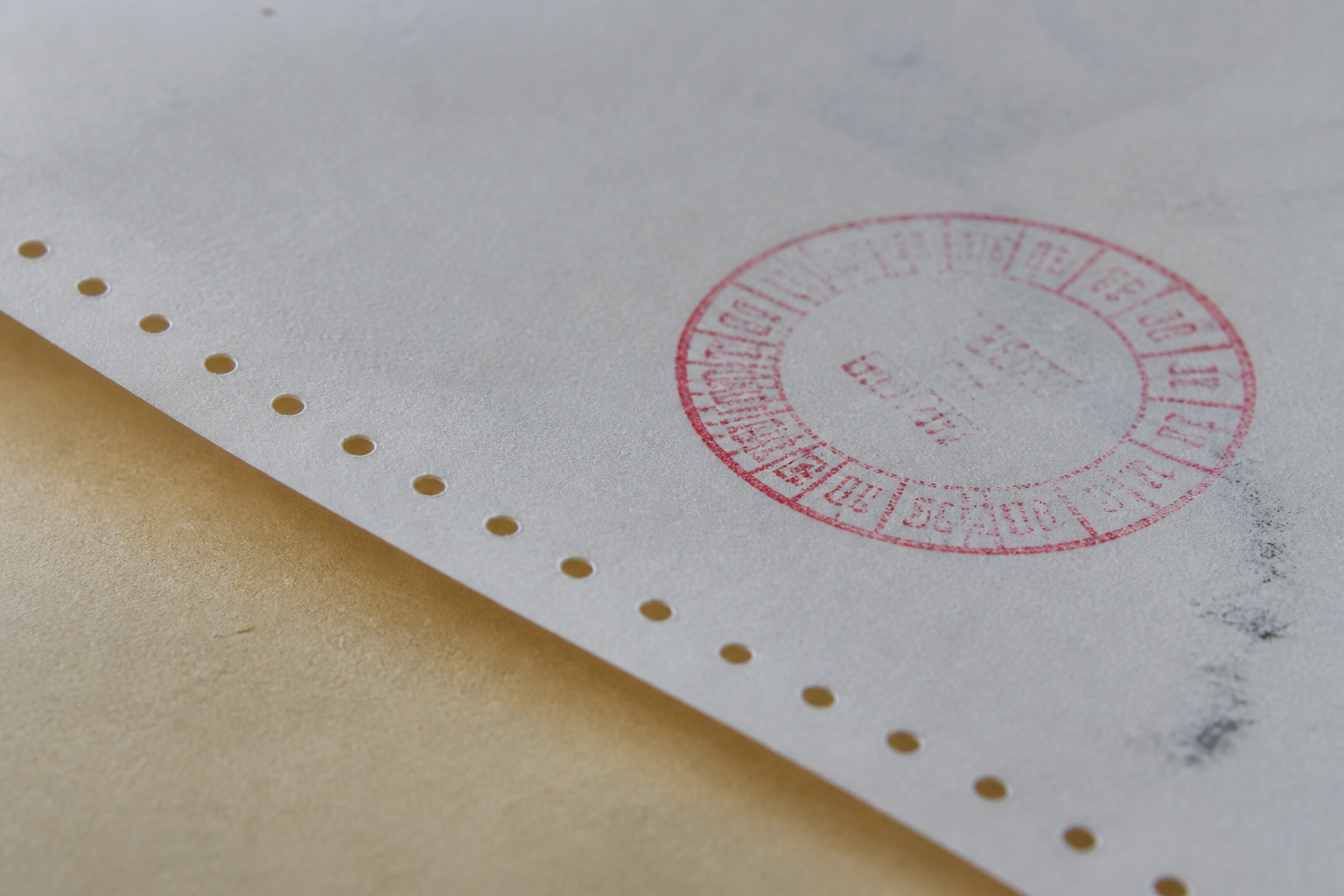 Perforated form edge with a faint received-date ink mark